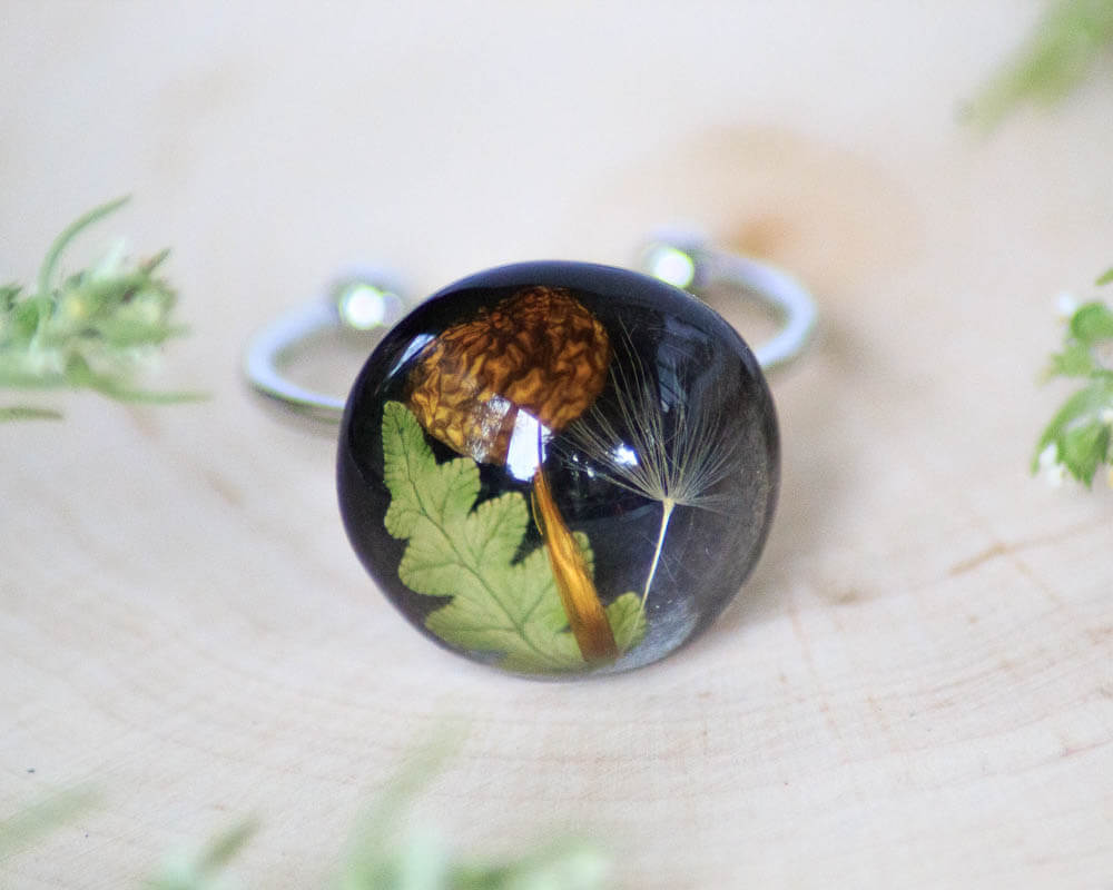 Adjustable ring with mushroom, leaf, and dandelion seed encapsulated in resin