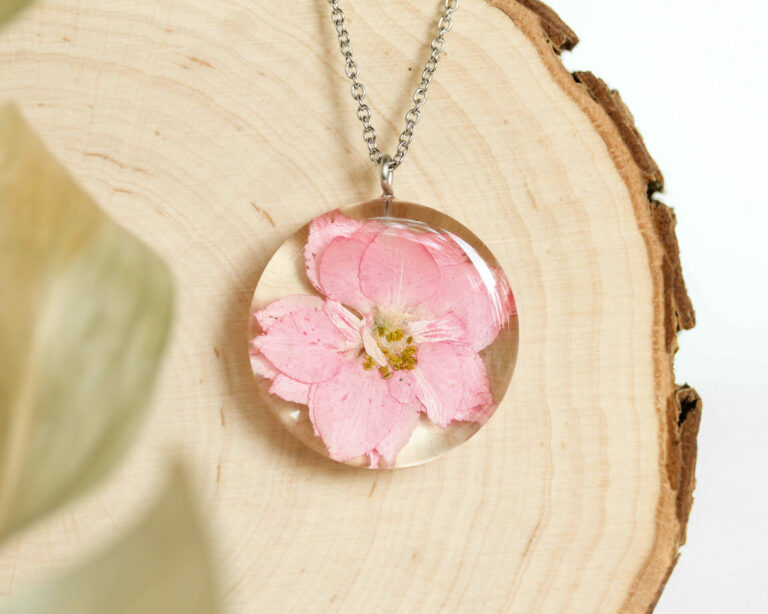 Close-up of August birth flower necklace with flower in resin.