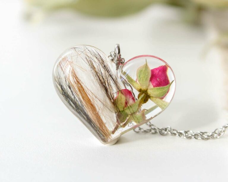 Heart-shaped resin necklace with encapsulated pet hair and dried pink rosebuds.