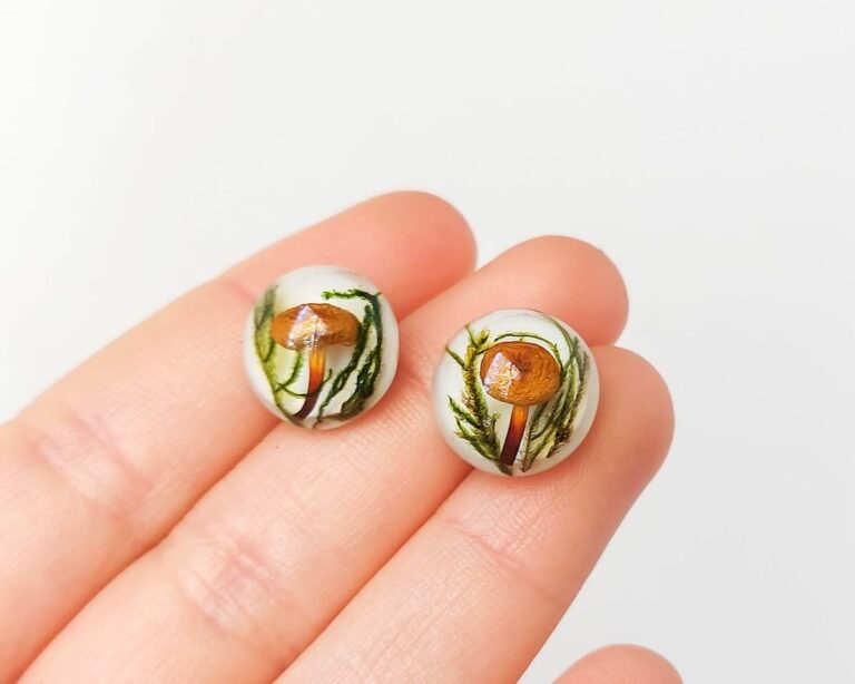 Close-up of handmade mushroom earring worn on ear.