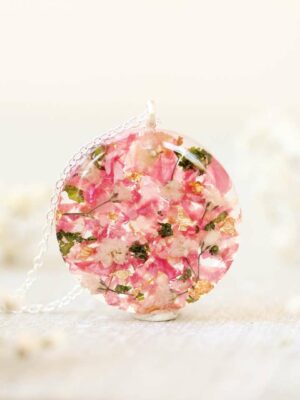 Custom resin keepsake necklace made with bride’s real wedding flowers in a round shape.