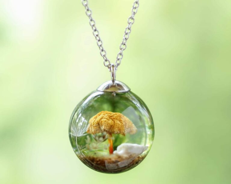 Handmade resin pendant by Botania Jewelry featuring a preserved real mushroom, dandelion seed, and forest details inside